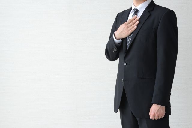 胸に手を当てるビジネスマン